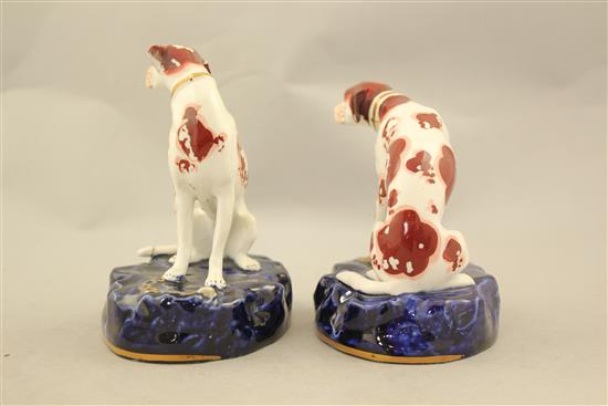 A pair of English porcelain figures of seated hounds, c.1830, 11.5cm and 12.5cm, flaking to enamels